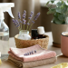 Cleaning essentials with spray bottle, microfiber cloths, natural brush, lavender, lemon and coffee on wooden desk, soft pastel Pinterest home cleaning routine scene 750x400