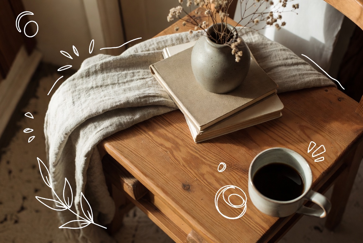 Cozy aesthetic wooden furniture flat lay with linen throw, books and dried flowers in warm neutral tones
