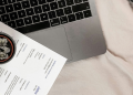 Professional resume document on a laptop keyboard with a small potted succulent plant, modern workspace setup for job search and career preparation