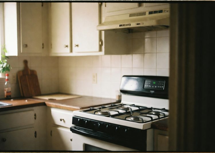 White and black gas stove in a clean kitchen, important safety reminder to always double-check that stove burners are turned off after cooking