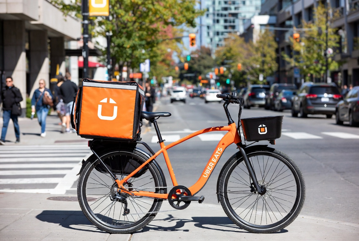 Orange Uber Eats delivery bicycle parked on a busy city street
