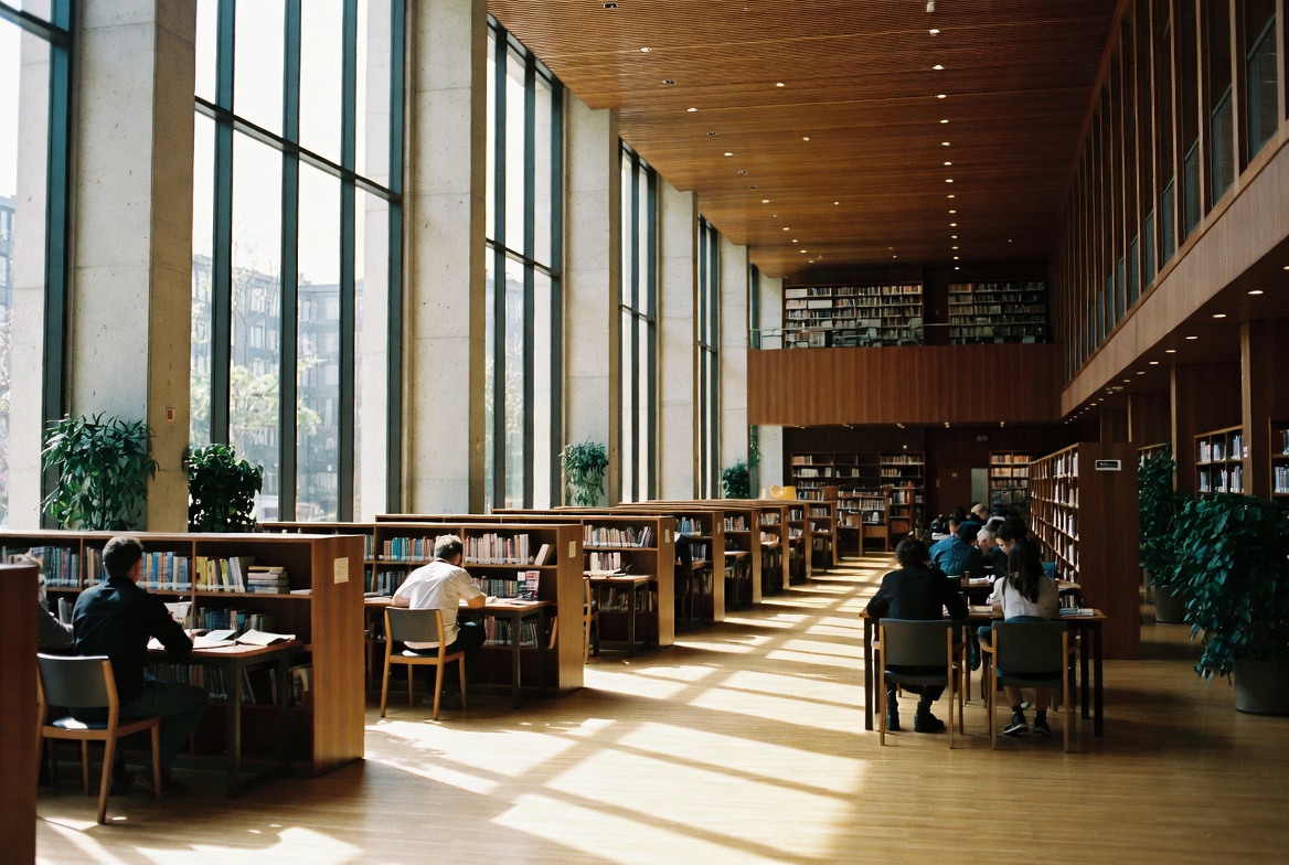Spacious modern library interior with students reading and studying at tables